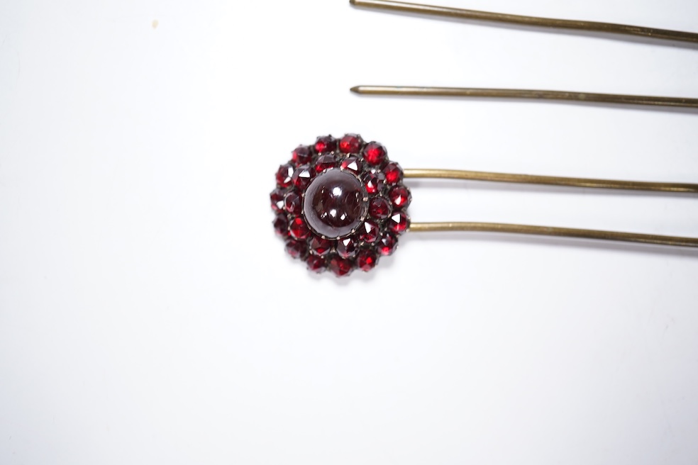 A Victorian yellow metal and garnet cluster set open work brooch, 27mm, together with two garnet cluster set hair ornaments. Condition - poor to fair